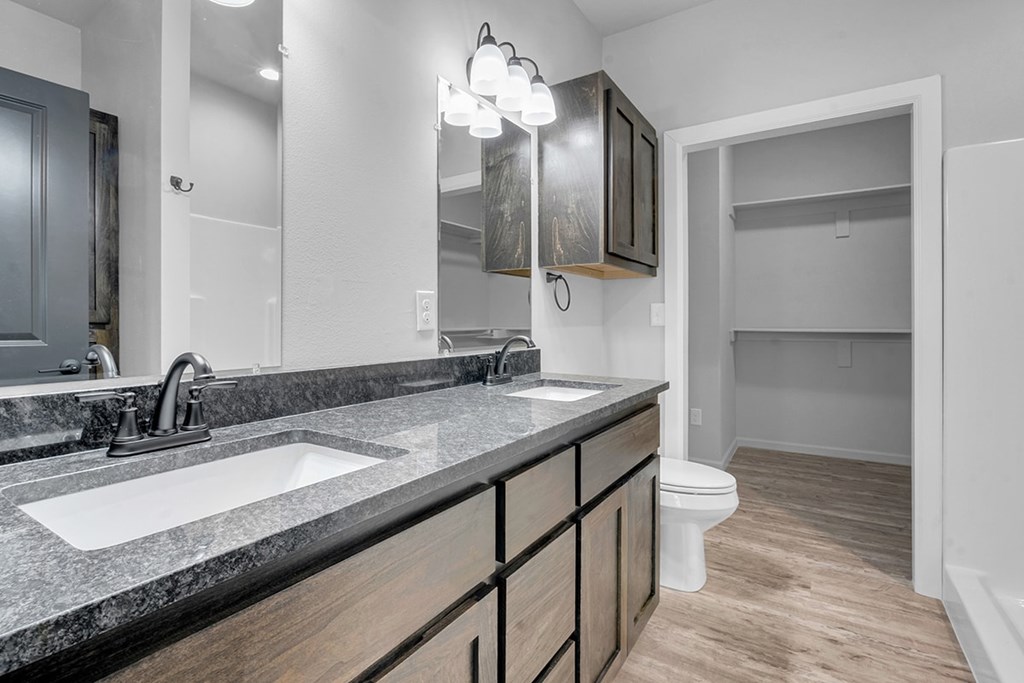 A bathroom with a sink, mirror, and toilet.