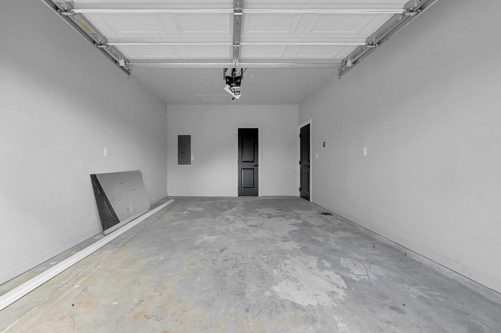A large empty room with a concrete floor and white walls.
