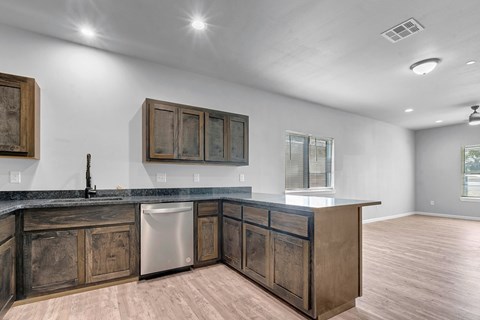 A kitchen with wooden cabinets and a marble countertop.