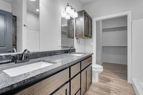 A bathroom with a sink, mirror, and toilet.
