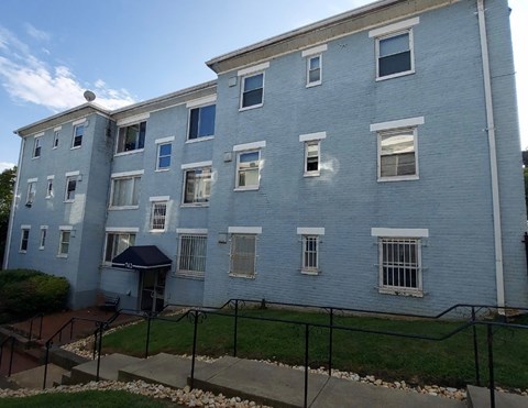 A blue building with a black fence in front.
