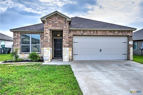A house with a brick facade and a white garage door.