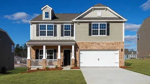 A two-story house with a garage and a covered porch.