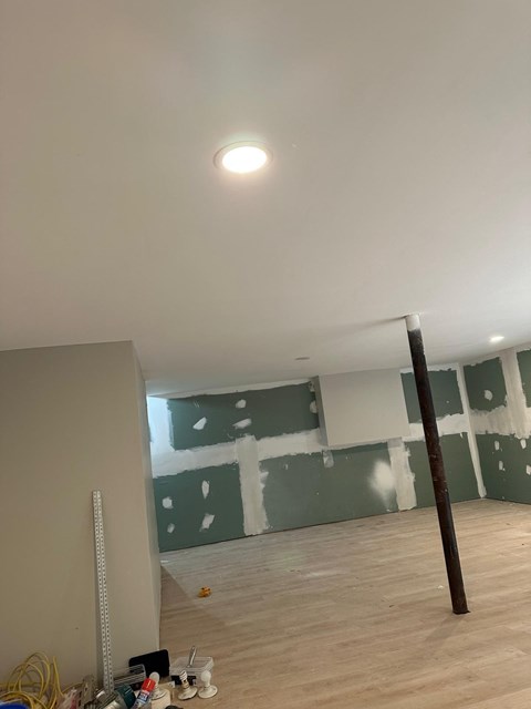 A room with a wooden floor and a white ceiling with a light fixture.