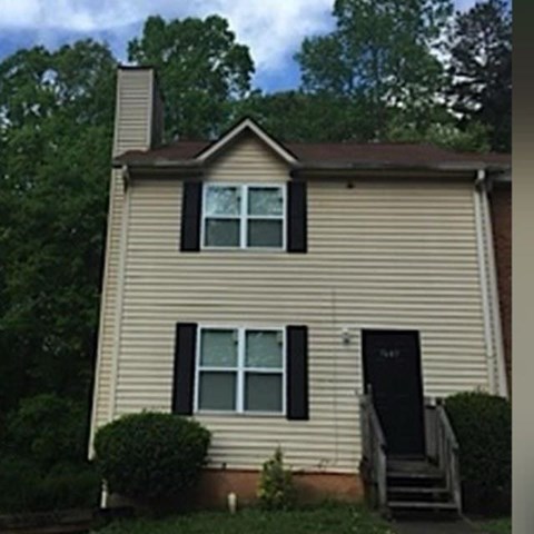 A house with a black door and a small porch.