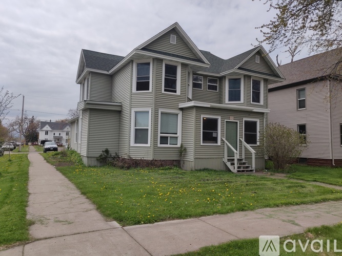 A two-story house with a grey exterior and a small front yard.