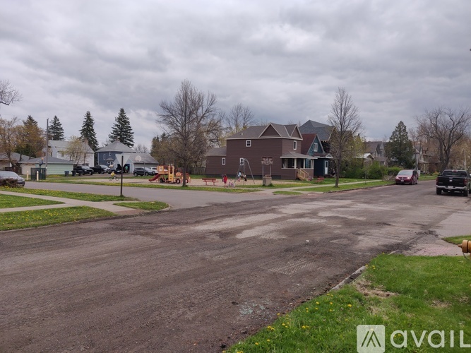 A cloudy day in a residential neighborhood with houses and driveways.