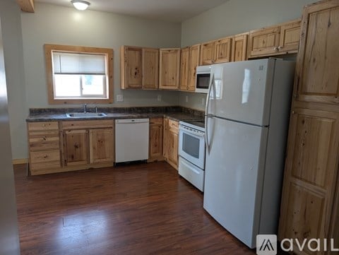 A kitchen with wooden cabinets and a white refrigerator.