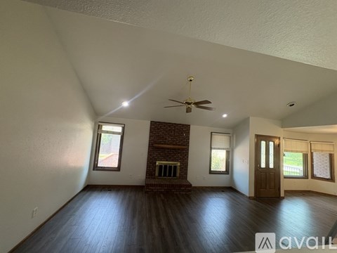 A room with a fireplace and a ceiling fan.