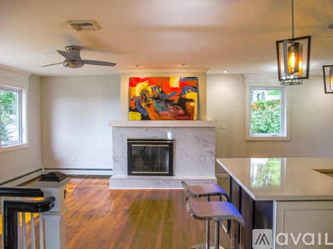 A living room with a fireplace and a painting on the wall.