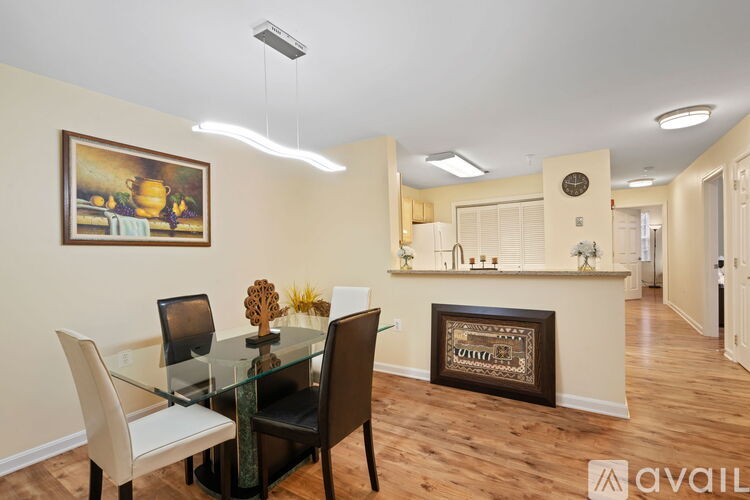 A modern dining room with a glass table and chairs.