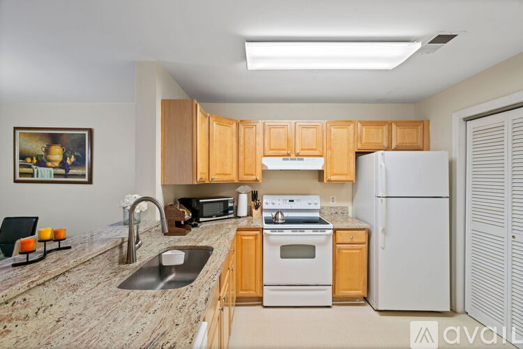 A kitchen with wooden cabinets and a white refrigerator.
