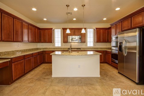 A kitchen with wooden cabinets and a marble countertop.