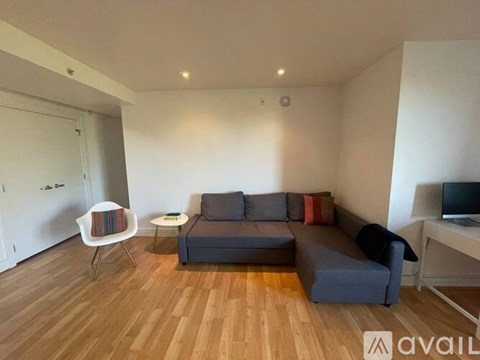 A living room with a grey couch and a white chair.