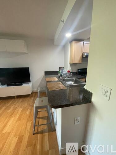 A kitchen with a sink and a TV.