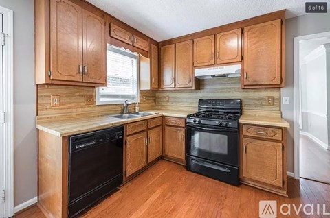 A kitchen with wooden cabinets and black appliances.