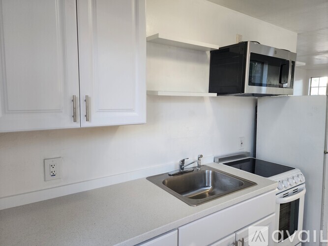 A kitchen with white cabinets and a white oven.
