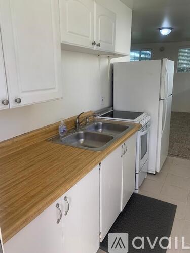 A kitchen with white cabinets and a wooden countertop.