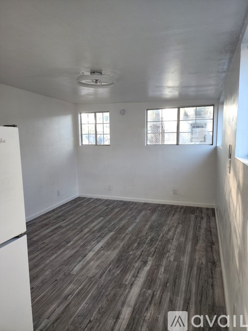 A hallway with a carpeted floor and a light on the wall.