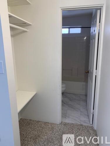 A white bathroom with a toilet and a shower.