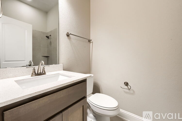 A bathroom with a toilet, sink, and shower.