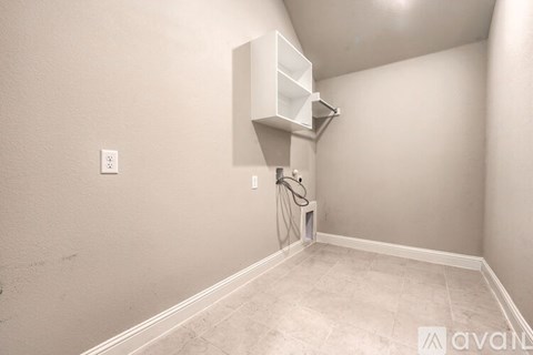 A room with a white cabinet and a shower head.