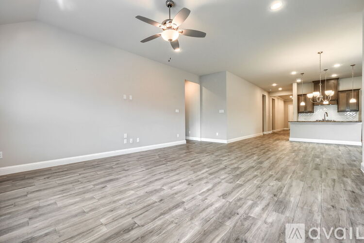 A spacious room with a ceiling fan and wooden flooring.