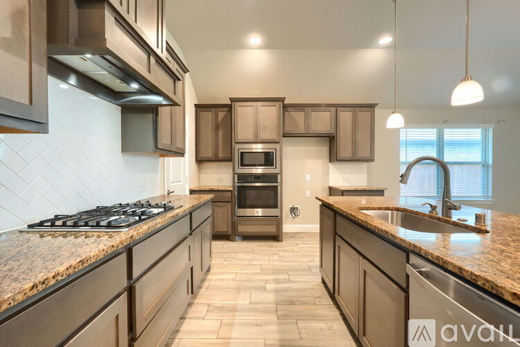 A kitchen with brown cabinets and a granite countertop.