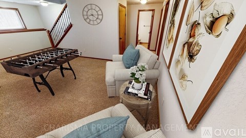 A living room with a foosball table and a painting of mushrooms on the wall.