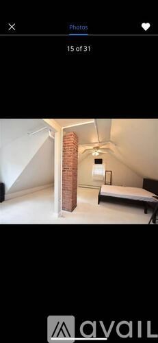 A bedroom with a bed, a nightstand, and a lamp.