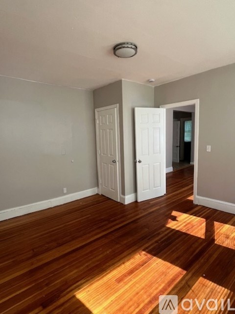 A room with wooden floors and two white doors.