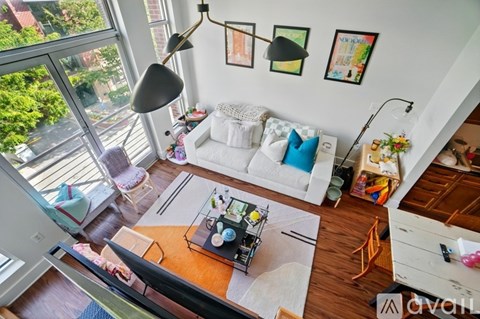 A living room with a white couch and a large window.