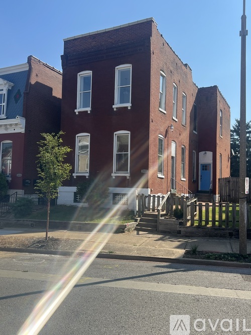 A red brick building with a tree in front of it.