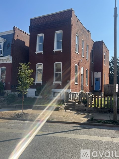 A red brick building with a tree in front of it.