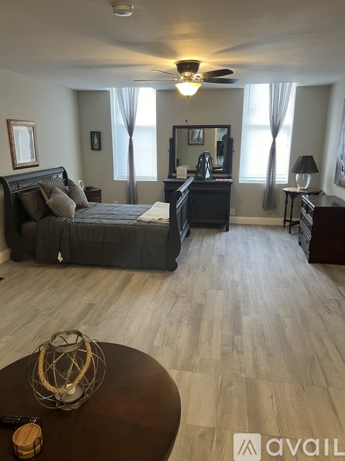 A bedroom with a large bed and a dresser with a mirror.