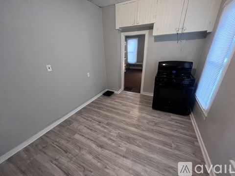 A room with a wooden floor and a black cabinet.