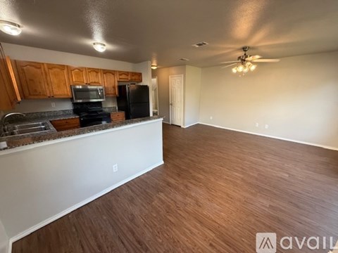 A kitchen with wooden cabinets and a black refrigerator.