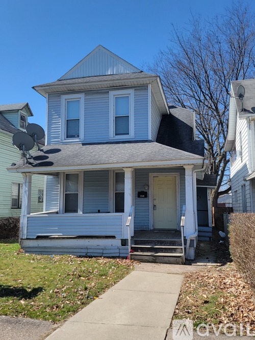 A two-story house with a white door and a satellite dish on the roof.