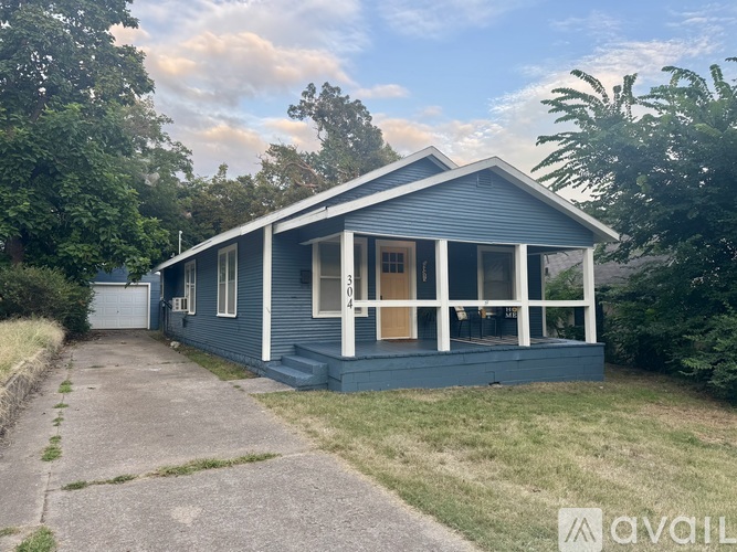 A blue house with a white door and windows is for sale.