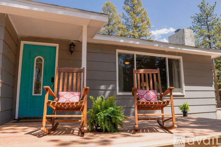Two wooden rocking chairs are placed on a porch.