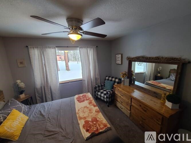 A bedroom with a bed, dresser, and mirror.