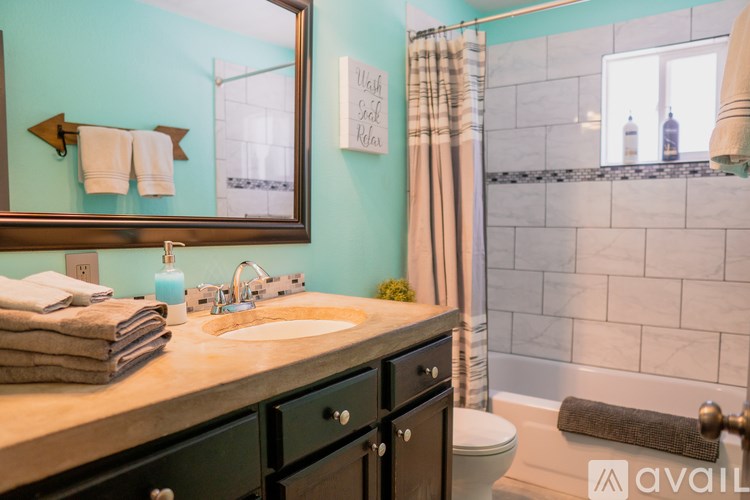 A bathroom with a sink, toilet, and a mirror.