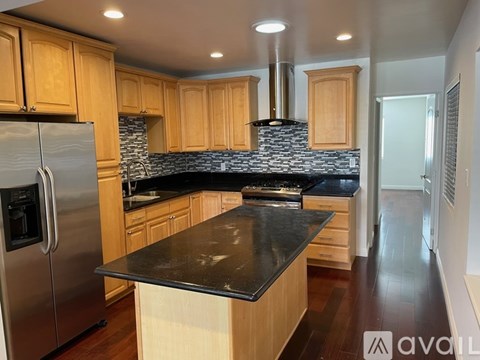 A kitchen with wooden cabinets and a black countertop.