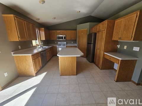 A kitchen with wooden cabinets and a tiled floor.