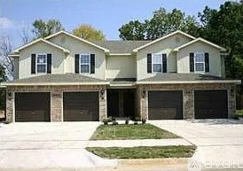 A two-story house with a garage on the lower level.
