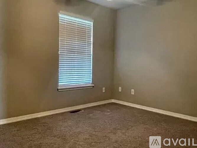A room with a window and carpeted floor.