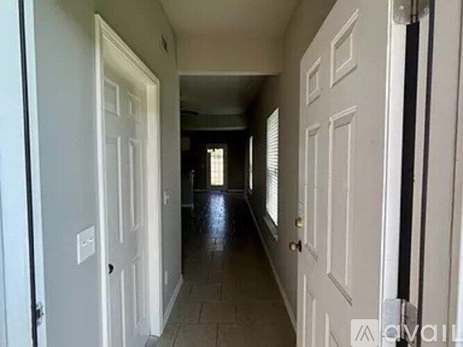 A long hallway with white doors on both sides.