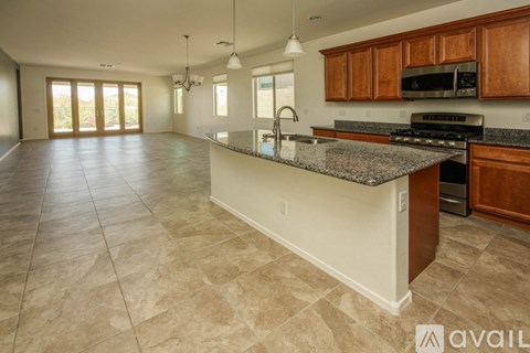 A kitchen with a granite countertop and wooden cabinets.