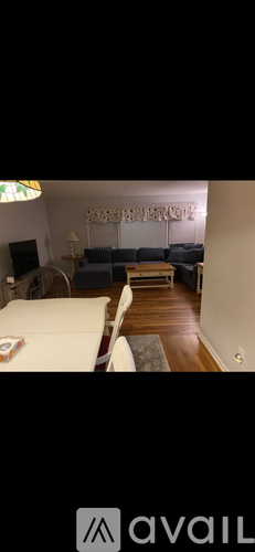 A living room with a white couch and a wooden floor.