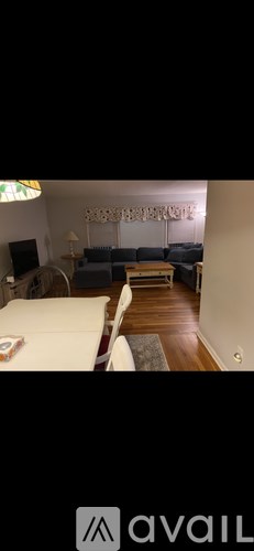 A living room with a white couch and a wooden floor.